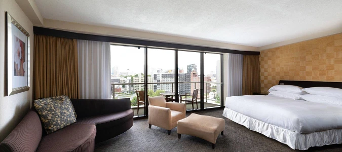 A room with a bed and chairsAI-generated content may be incorrect.