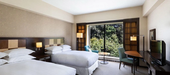 A room with two beds and a windowAI-generated content may be incorrect.