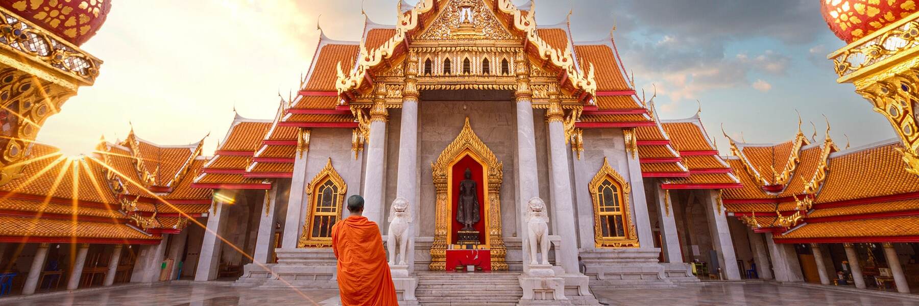 a monk stands infront of a temple located in laem chabang bangkok